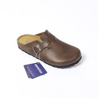 zoccoli birkenstock, calzature ergonomiche, zoccoli in pelle, calzature casual, suola antiscivolo, scarpe traspiranti. Un paio di zoccoli Birkenstock dal design ergonomico, realizzati in pelle di alta qualità, sono mostrati su uno sfondo neutro. La suola antiscivolo garantisce sicurezza, mentre la struttura traspirante è ideale per l’uso quotidiano, offrendo comfort e stile nelle calzature casual.